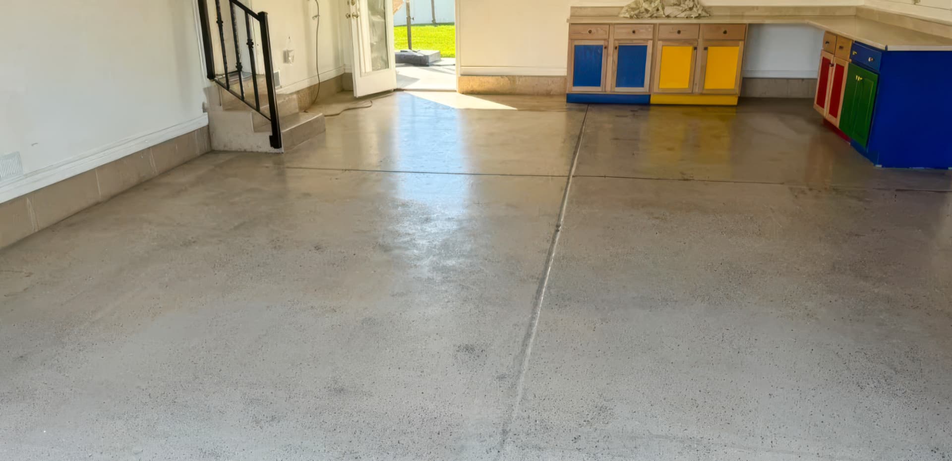 Bare stained concrete garage floor before a flake coating in Utah.